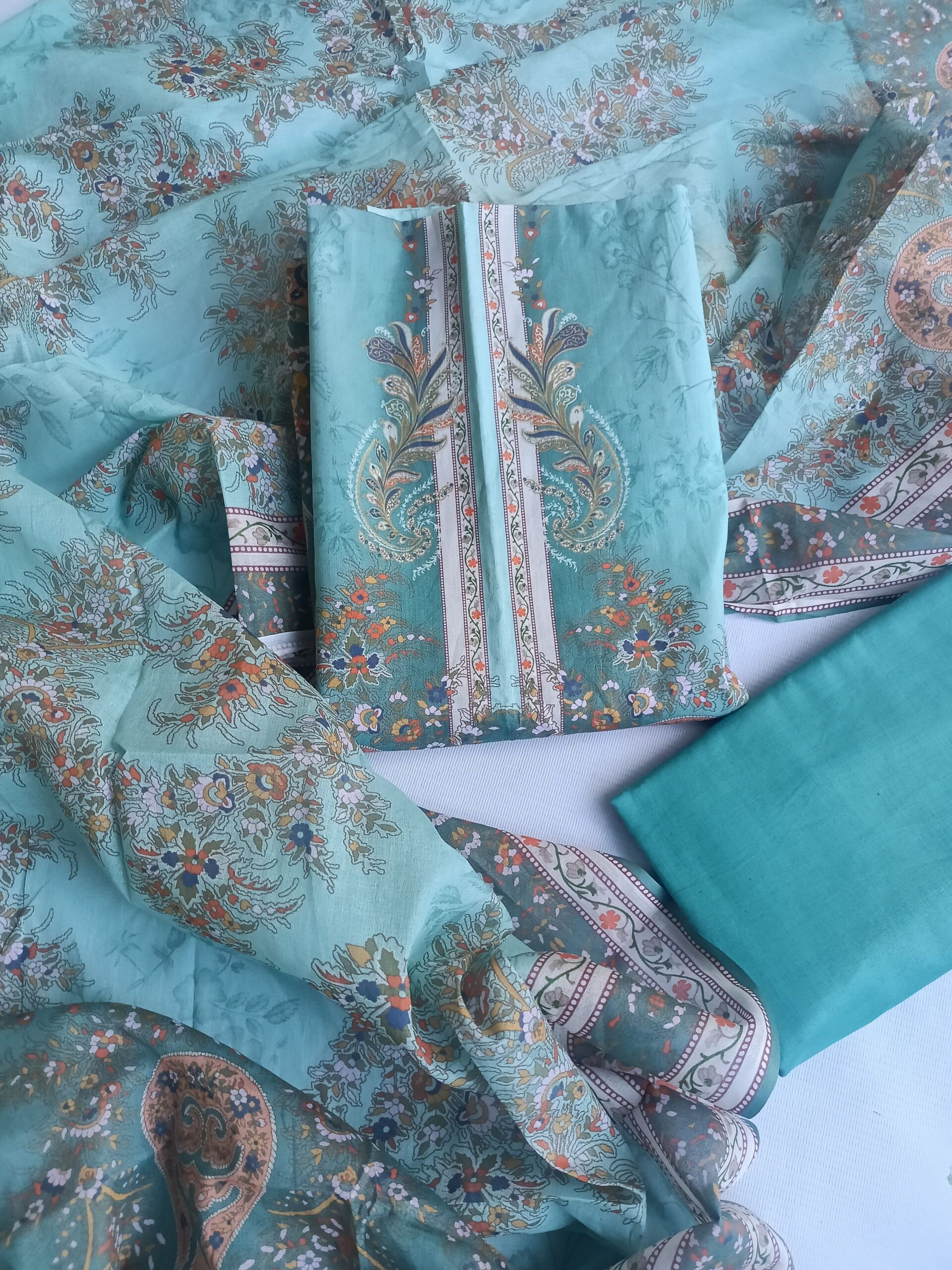pexels photo 37608683 37608683 A collection of elegant turquoise fabrics adorned with intricate floral patterns, ideal for fashion projects.
